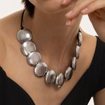 Colier statement handmade Vestopazzo, purtat pe gât, compus din elemente rotunde plate din aluminiu reciclat