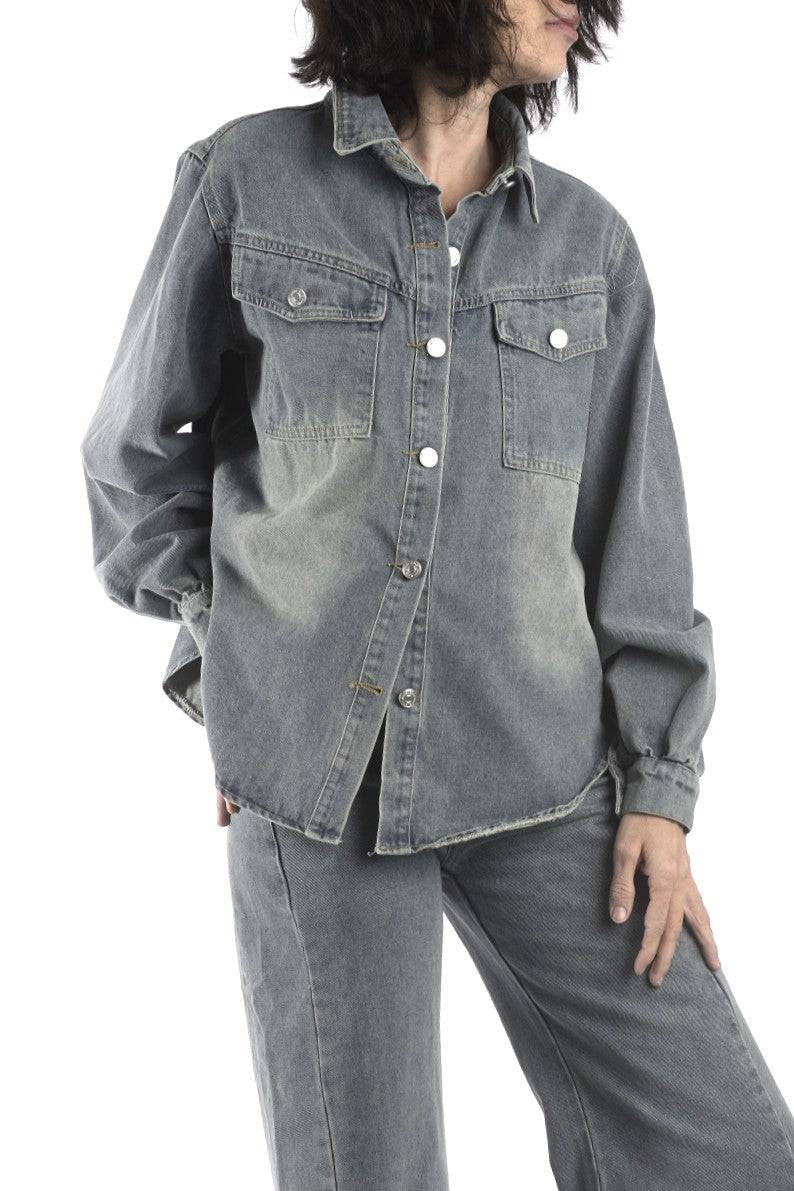 Detaliu bluză din denim gri, cu croială relaxată, buzunare aplicate și nasturi frontali.