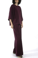 Detaliu bluză cu umeri căzuți și finisaj curat, material elastic cu textură fină.