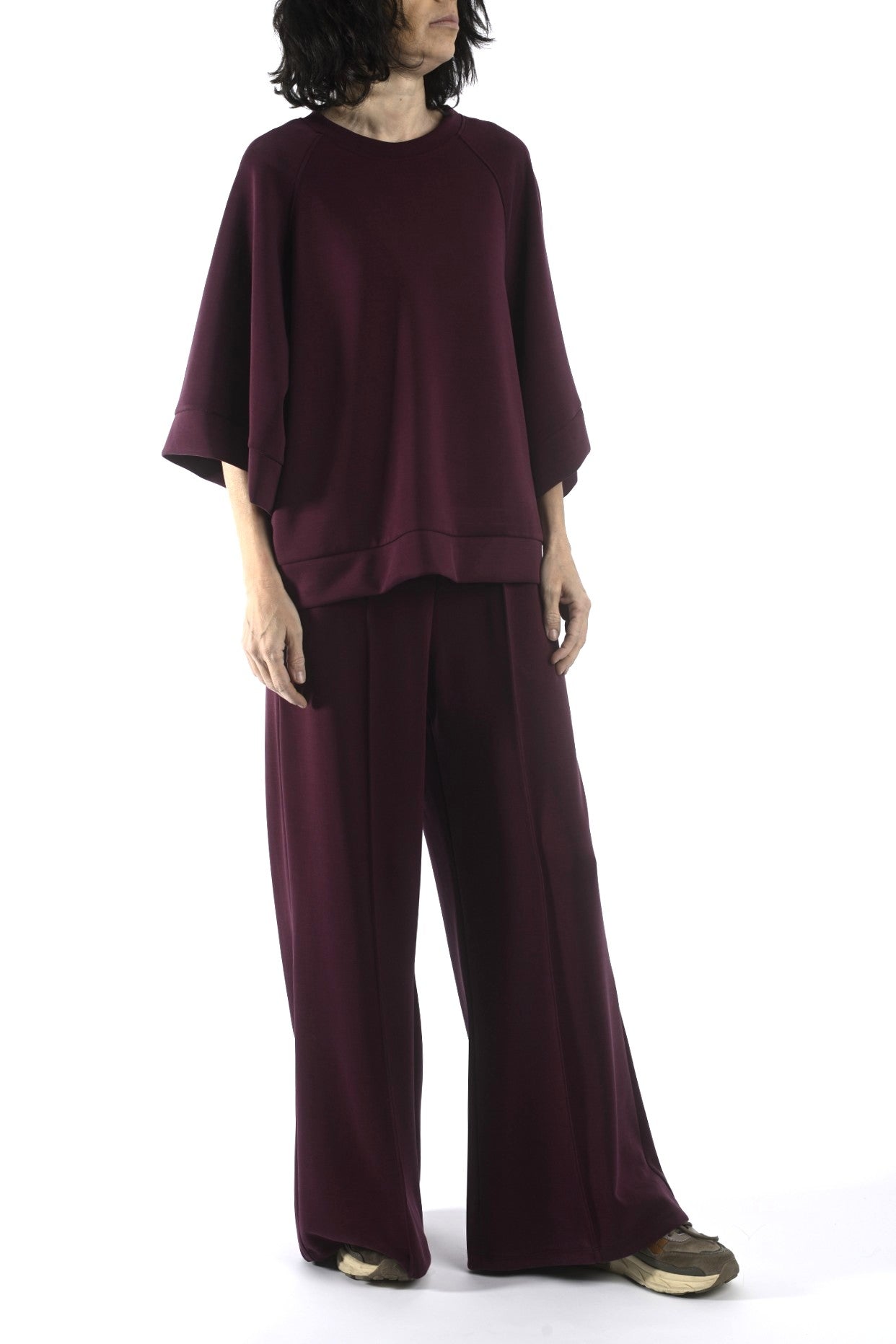 Vedere laterală a compleului bordo, evidențiind croiala fluidă și căderea materialului.