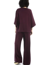 Detaliu bluză cu umeri căzuți și finisaj curat, material elastic cu textură fină.