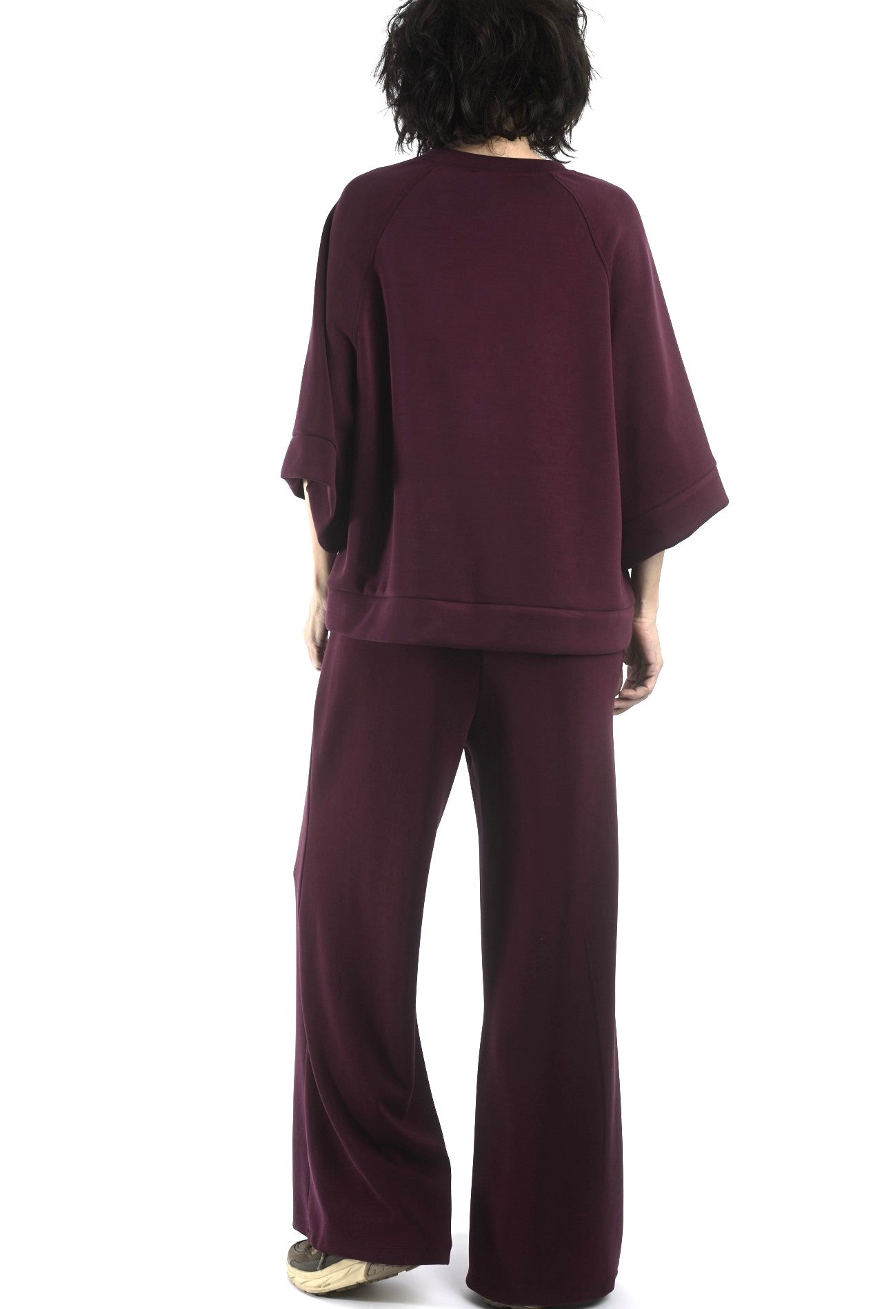 Detaliu bluză cu umeri căzuți și finisaj curat, material elastic cu textură fină.