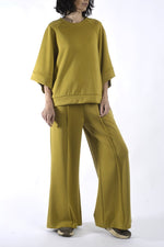 Compleu lejer din vâscoză verde muștar, cu bluză cu umeri căzuți și pantaloni largi, purtare frontală.