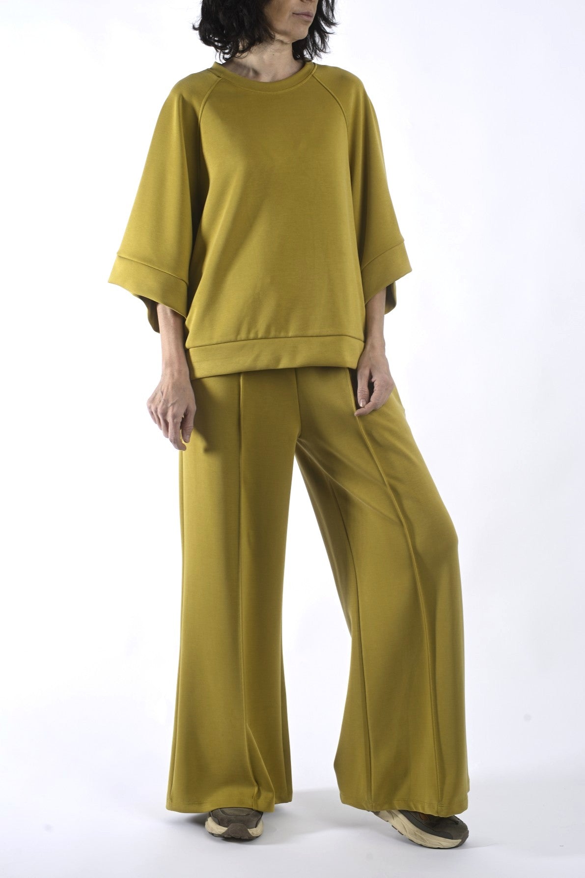 Compleu lejer din vâscoză verde muștar, cu bluză cu umeri căzuți și pantaloni largi, purtare frontală.