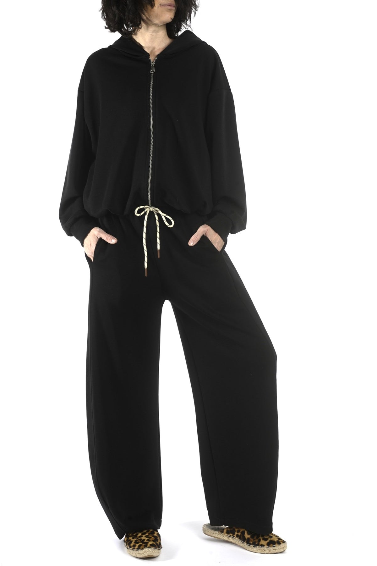 Compleu negru cu hanorac cu glugă și fermoar și pantaloni largi cu talie elastică, fotografie frontală.