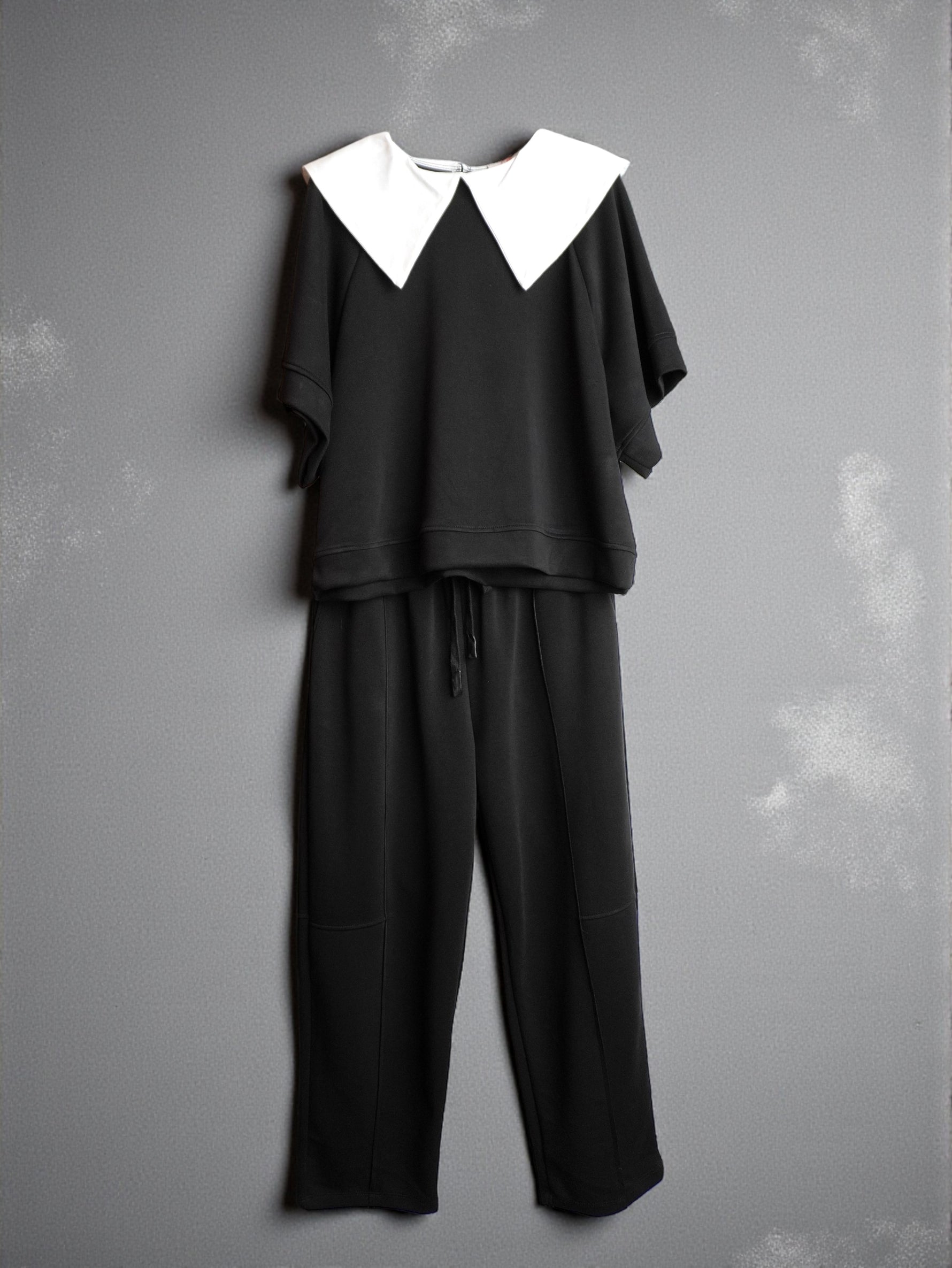 Compleu negru cu bluză cu rever alb contrastant și pantaloni drepți, vedere frontală.