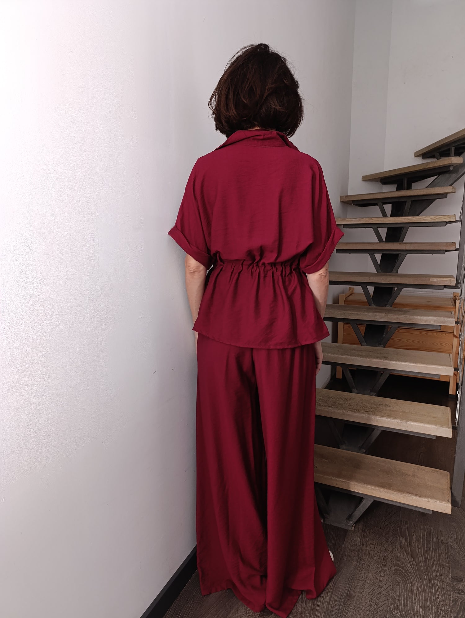  Spatele compleului bordo, cu bluză ajustată în talie și pantaloni largi
