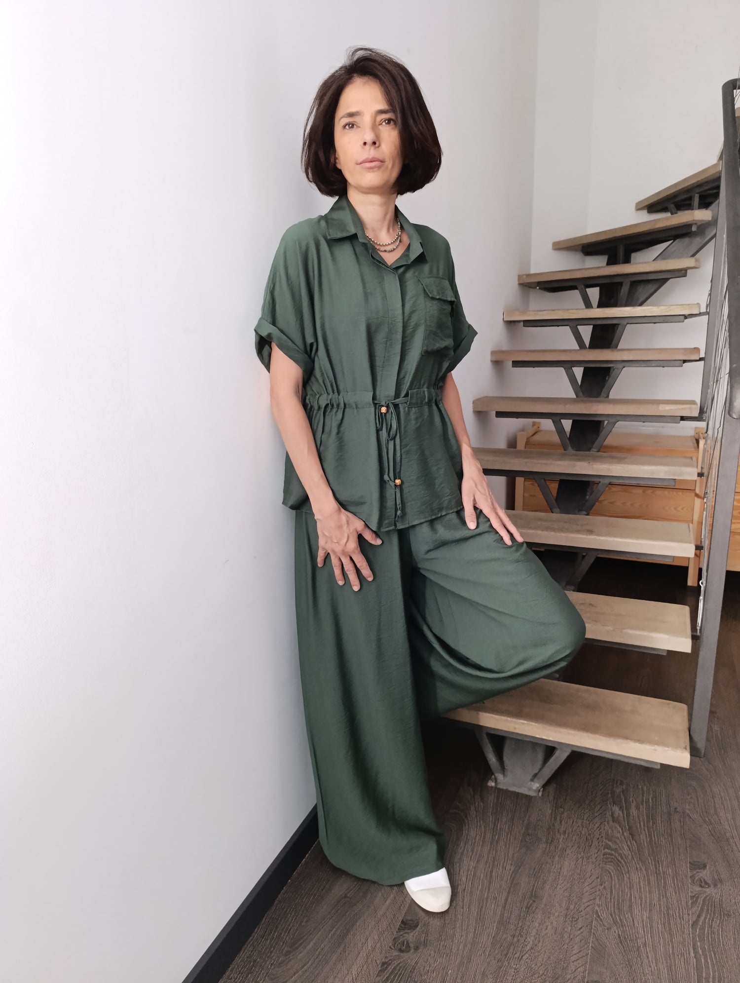 Compleu verde kaki cu pantaloni largi și bluză cu cordon, model sprijinit de treaptă