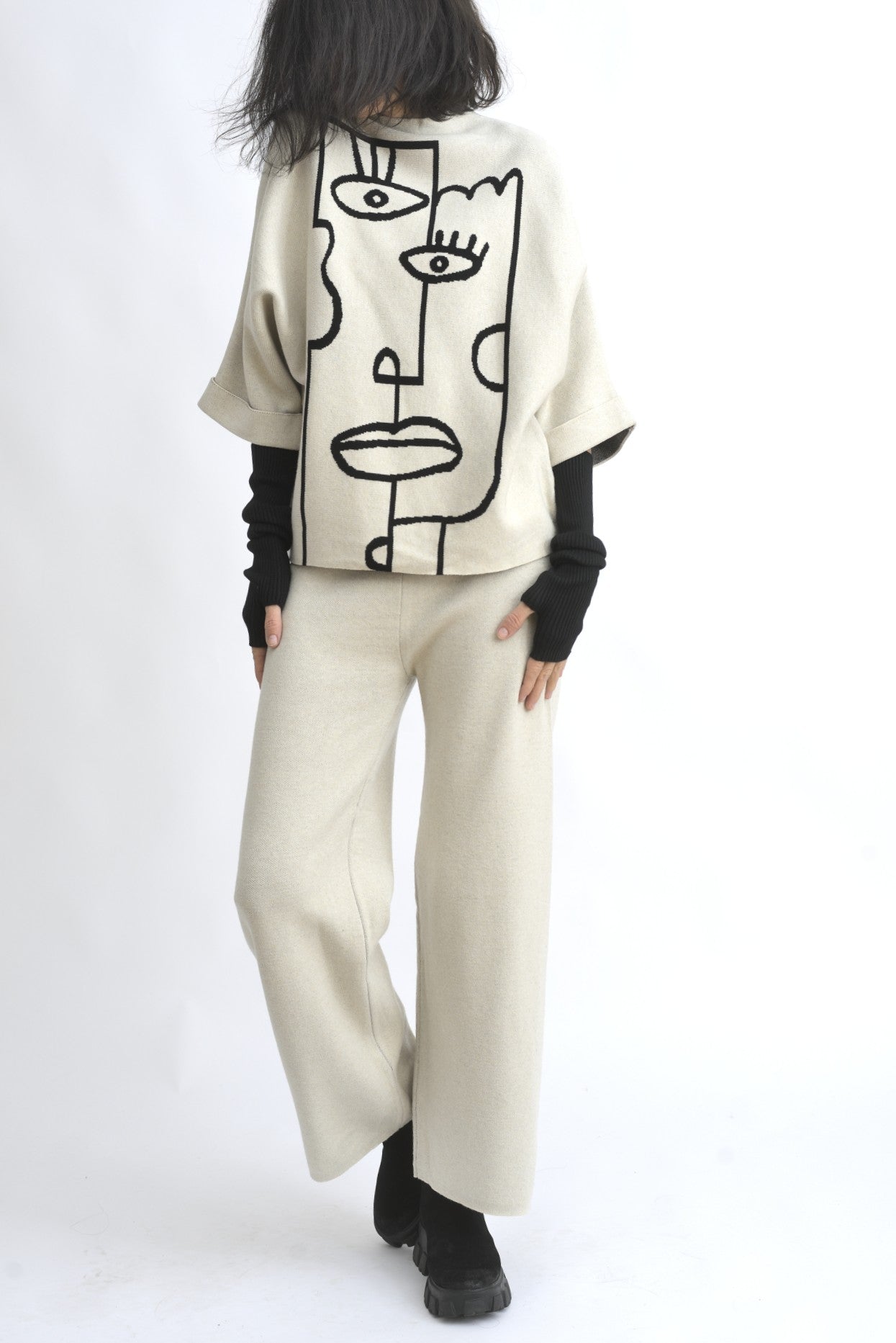 Vedere din spate a compleului bej, cu top lejer și pantaloni largi din tricot, talie elastică.