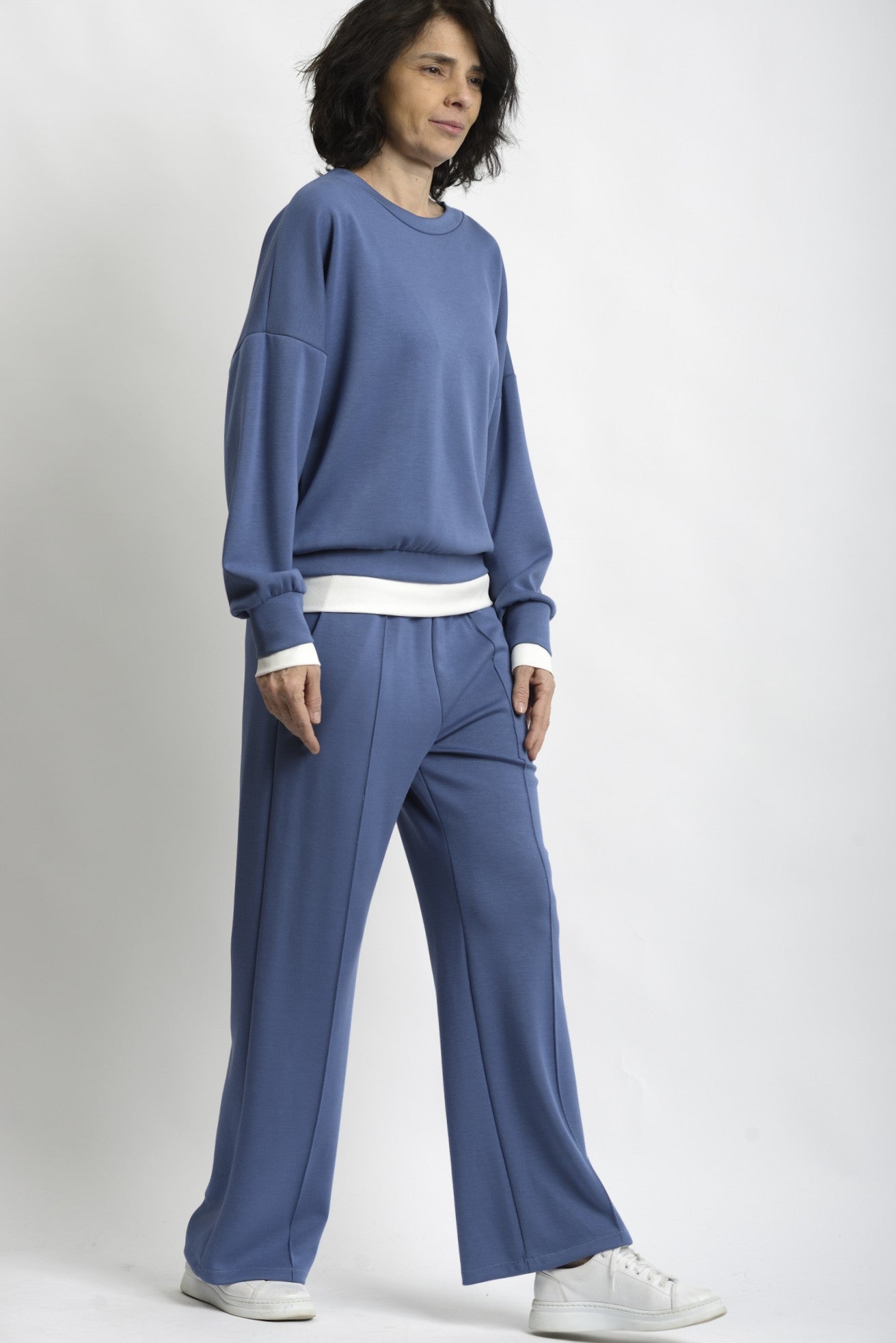 Compleu de trening albastru cu bluză lejeră și pantaloni drepți, cu terminație din tricot alb.