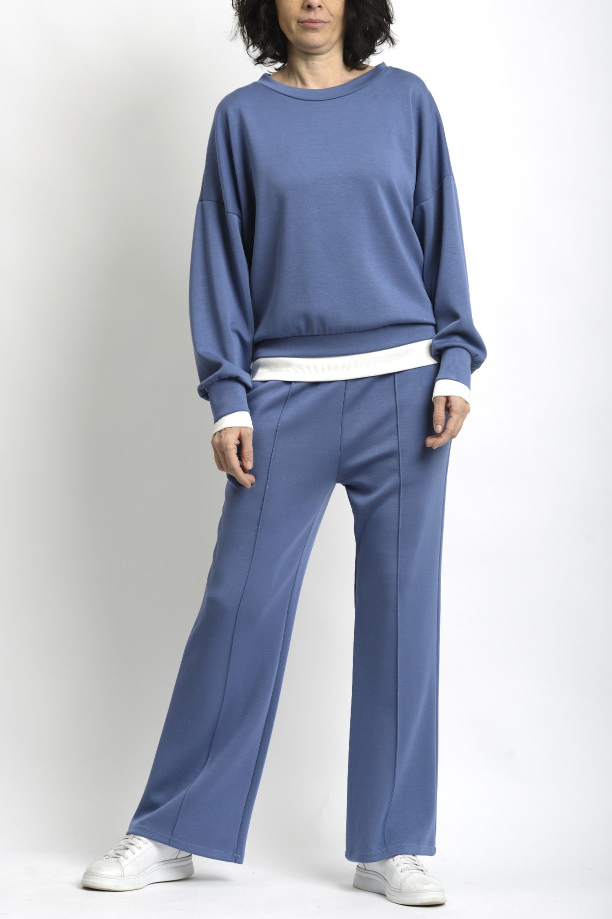 Compleu de trening albastru cu bluză lejeră și pantaloni drepți, cu terminație din tricot alb.