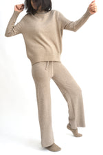 Compleu crem din tricot cu top lejer și pantaloni evazați, realizat din material moale și elastic.