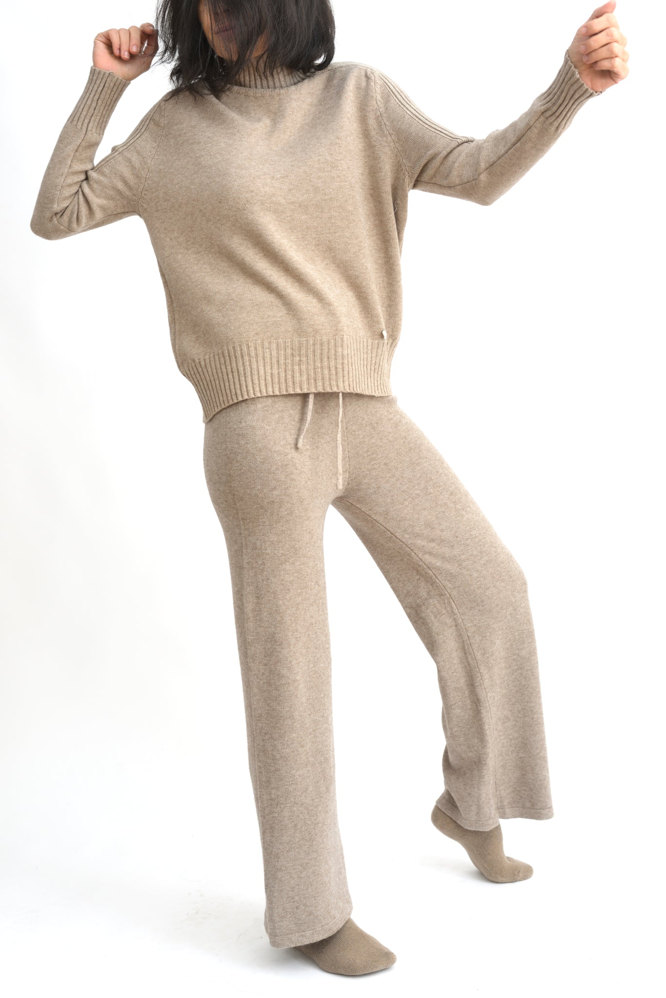 Compleu crem din tricot cu top lejer și pantaloni evazați, realizat din material moale și elastic.