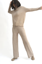 Compleu crem din tricot cu top lejer și pantaloni evazați, realizat din material moale și elastic.