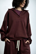 Compleu damă lejer, bluză tip hanorac cu mesaj brodat „astăzi sunt pe vibe zen”, purtat cu pantaloni comozi, culoare vișiniu.