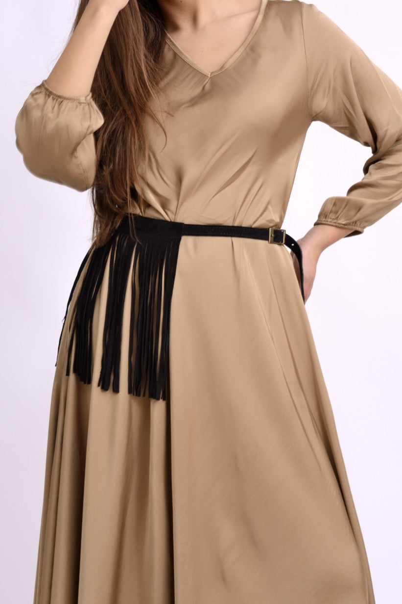 Detaliu de talie al unei curele negre din piele întoarsă cu franjuri, legată elegant peste rochie.