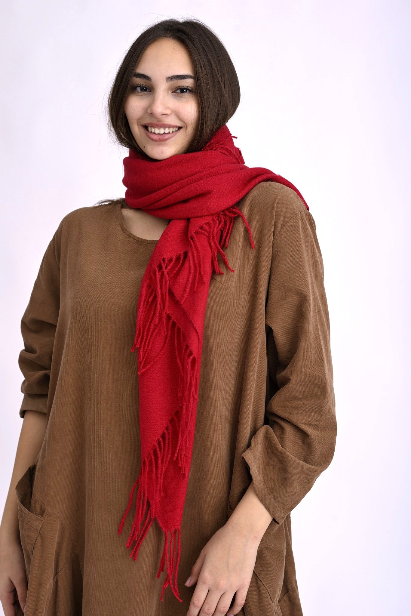 Eșarfă batic roșie cu franjuri lungi, din cașmir și viscoză, purtată peste o rochie maro.