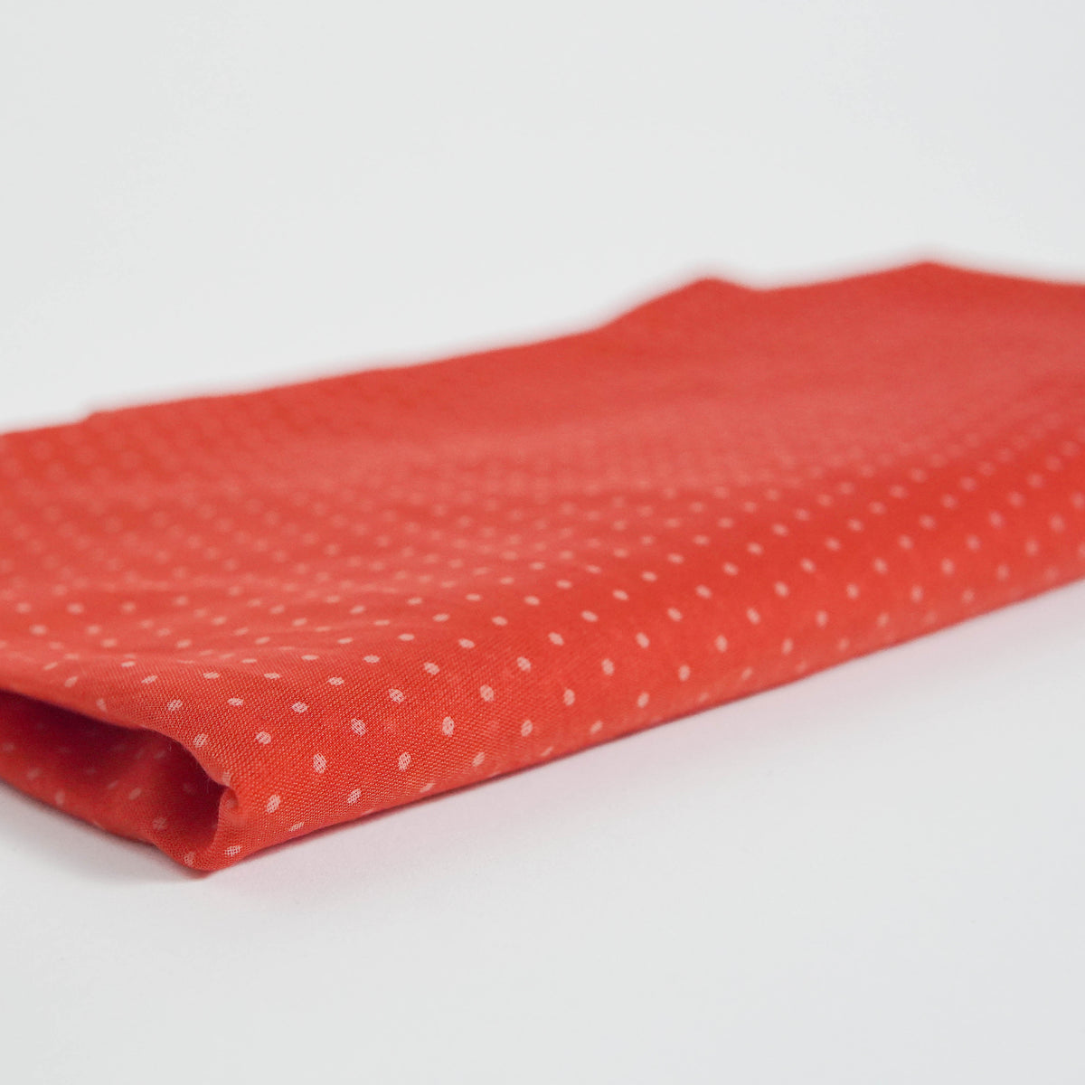 Material roșu texturat cu buline albe, pliat delicat, potrivit pentru ținute feminine.