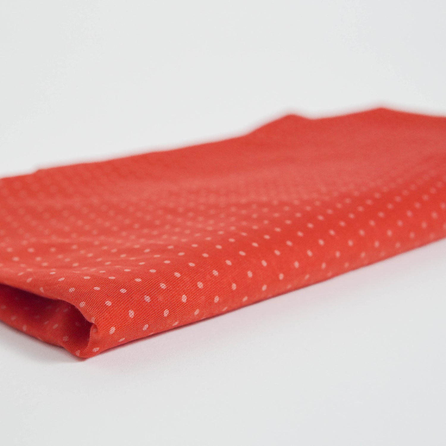 Material roșu texturat cu buline albe, pliat delicat, potrivit pentru ținute feminine.