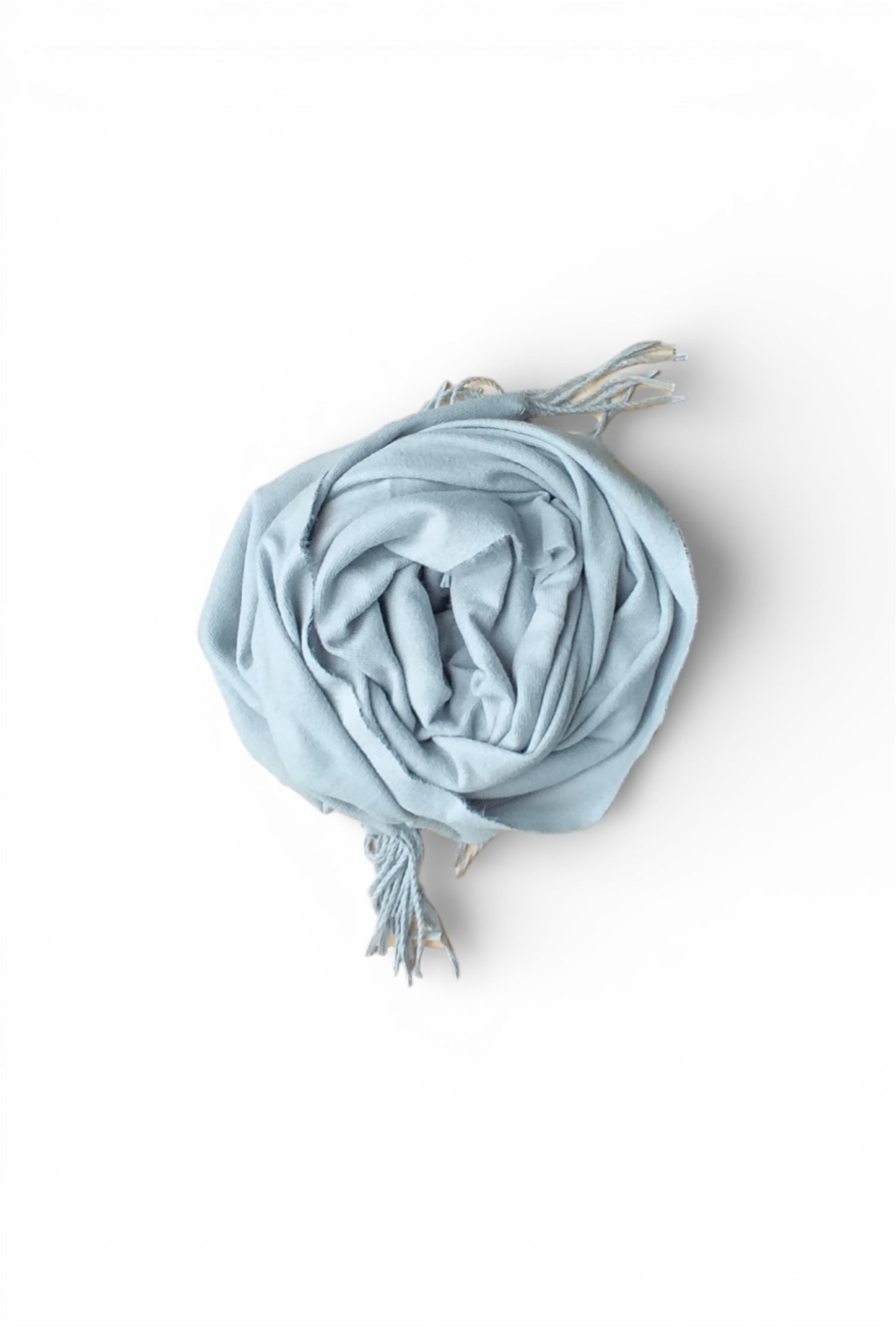 Eșarfă gri deschis, cu franjuri delicate, purtată clasic peste un pulover neutru, într-o compoziție echilibrată și atemporală.