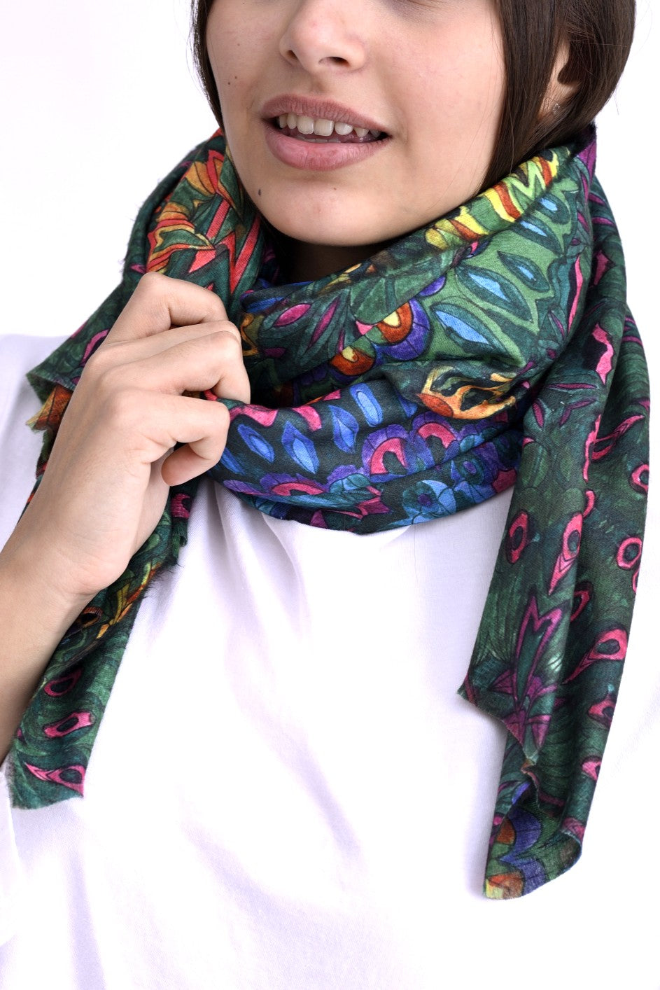 Detaliu al unei eșarfe multicolore cu imprimeu botanic, în nuanțe de verde, violet, albastru și portocaliu, purtată la o bluză albă.