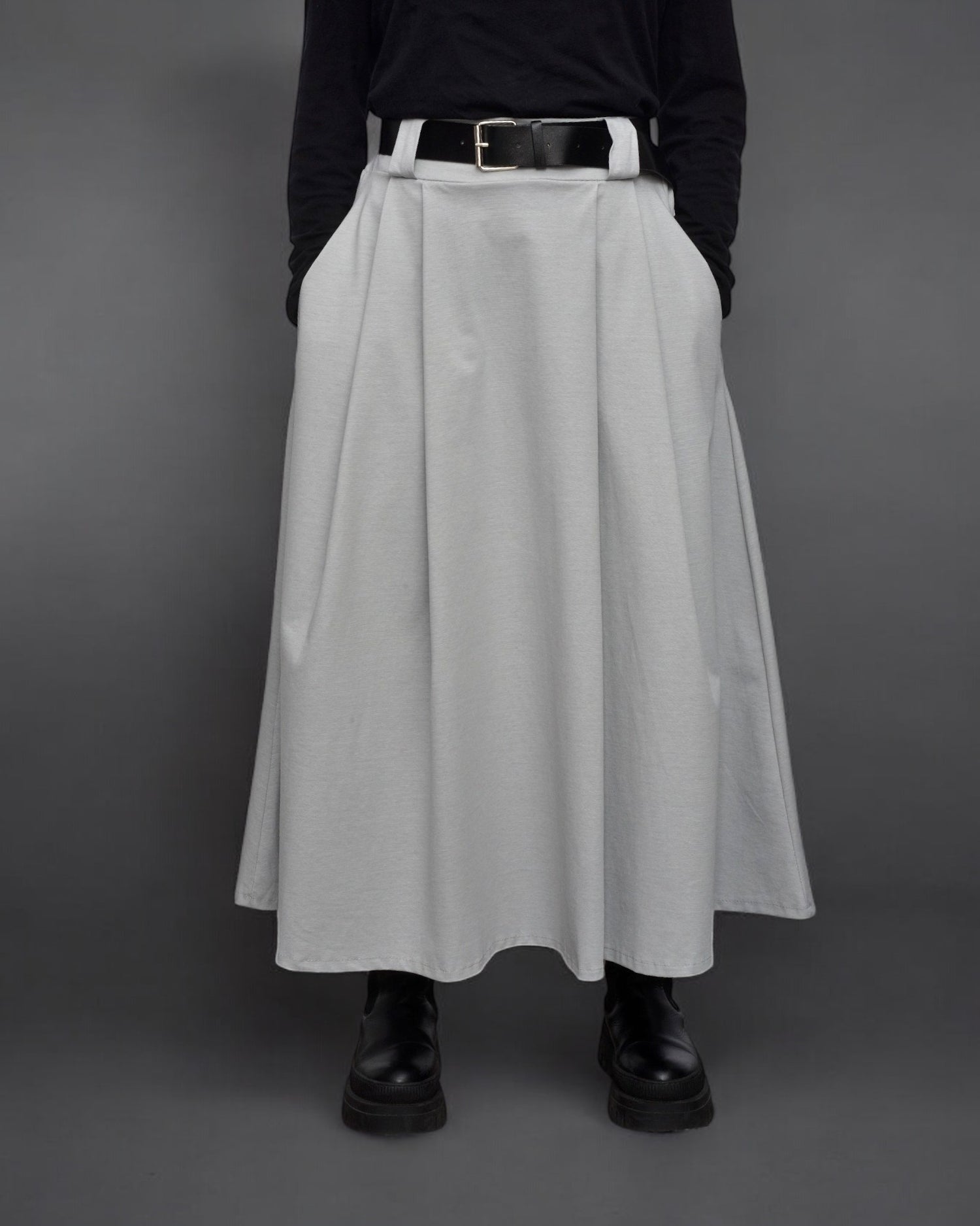 Fustă midi gri, combinată cu top negru și ghete masive, stil casual elegant.