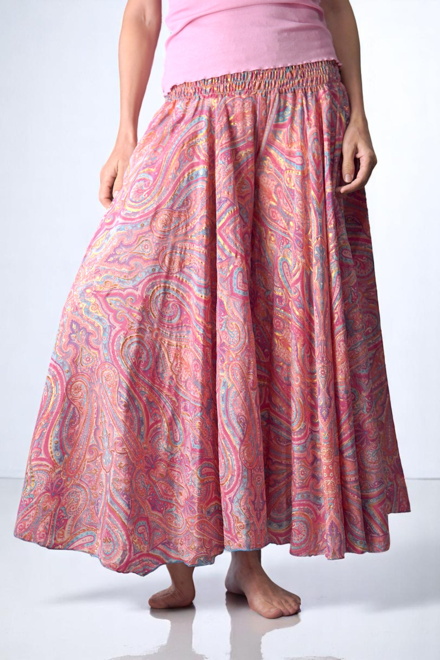 Fustă-pantalon tip șalvar în culori calde de roz, piersică și albastru pastel, cu imprimeu paisley. Talie elastică și croi amplu, pentru un look relaxat și feminin.