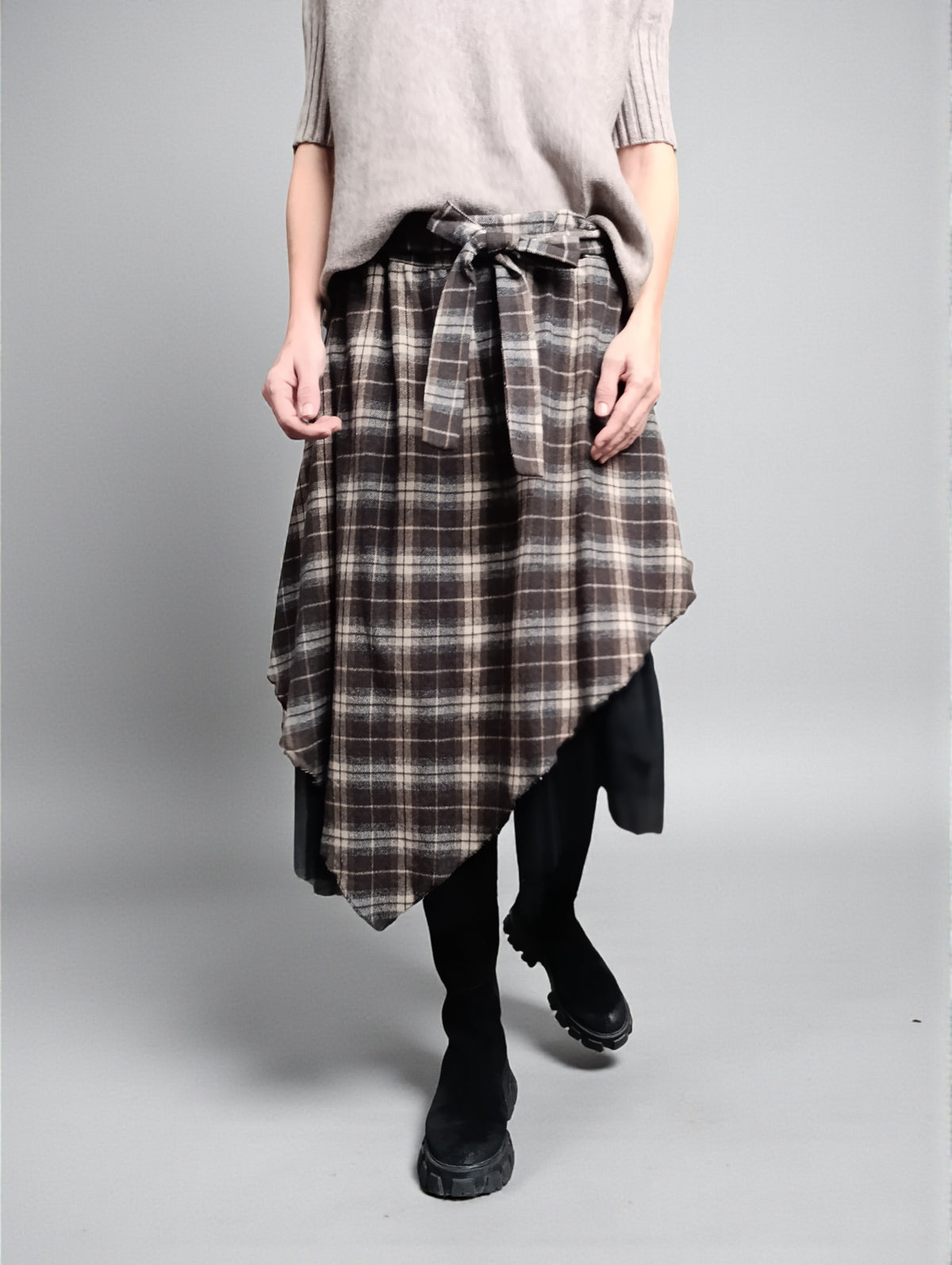 Detaliu talie elastică cu fundă textilă la fustă în carouri, finisaj lejer și strat de tul dedesubt.