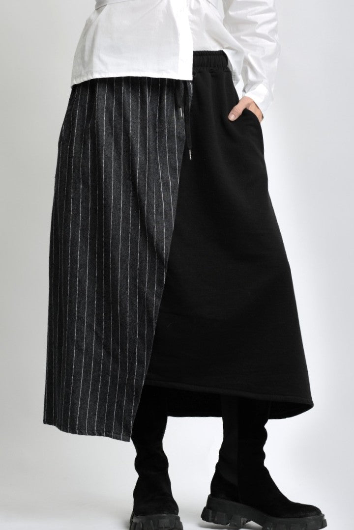 Detaliu de material al fustei din jerse cu inserție cu aspect de jeans, evidențiind textura și cusăturile.