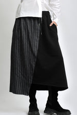 Detaliu de material al fustei din jerse cu inserție cu aspect de jeans, evidențiind textura și cusăturile.