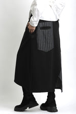 Vedere laterală a fustei asimetrice din jerse, cu contrast textural între materialul mat și cel tip jeans.