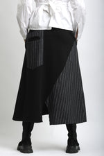 Spatele fustei asimetrice din jerse, cu lungime midi și cădere fluidă.