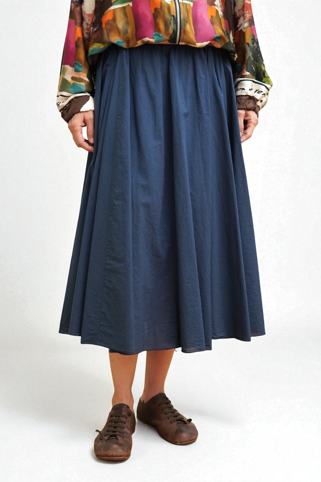 Fustă midi albastră din bumbac 100% cu jupon, purtată cu jachetă colorată în stil casual.