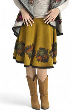 Detaliu al fustei din lână cu imprimeu floral brodat, textură moale și elastică.