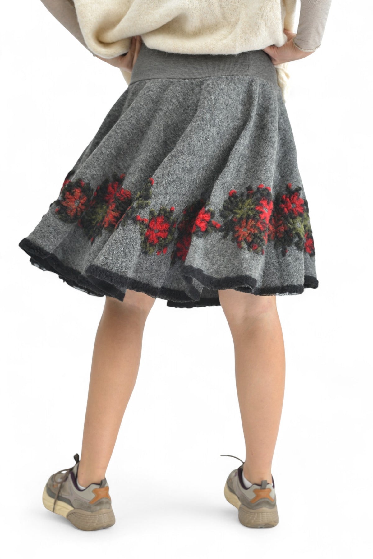 Fustă clopot din lână, cu imprimeu floral tradițional și croială feminină, purtată cu cizme bej.