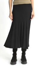 Fustă evazată din tricot ajurat negru, prezentată frontal pe model, cu talie elastică și cădere fluidă.