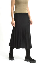 Fustă evazată neagră din tricot ajurat, fotografiată lateral pentru a evidenția textura și lejeritatea materialului.