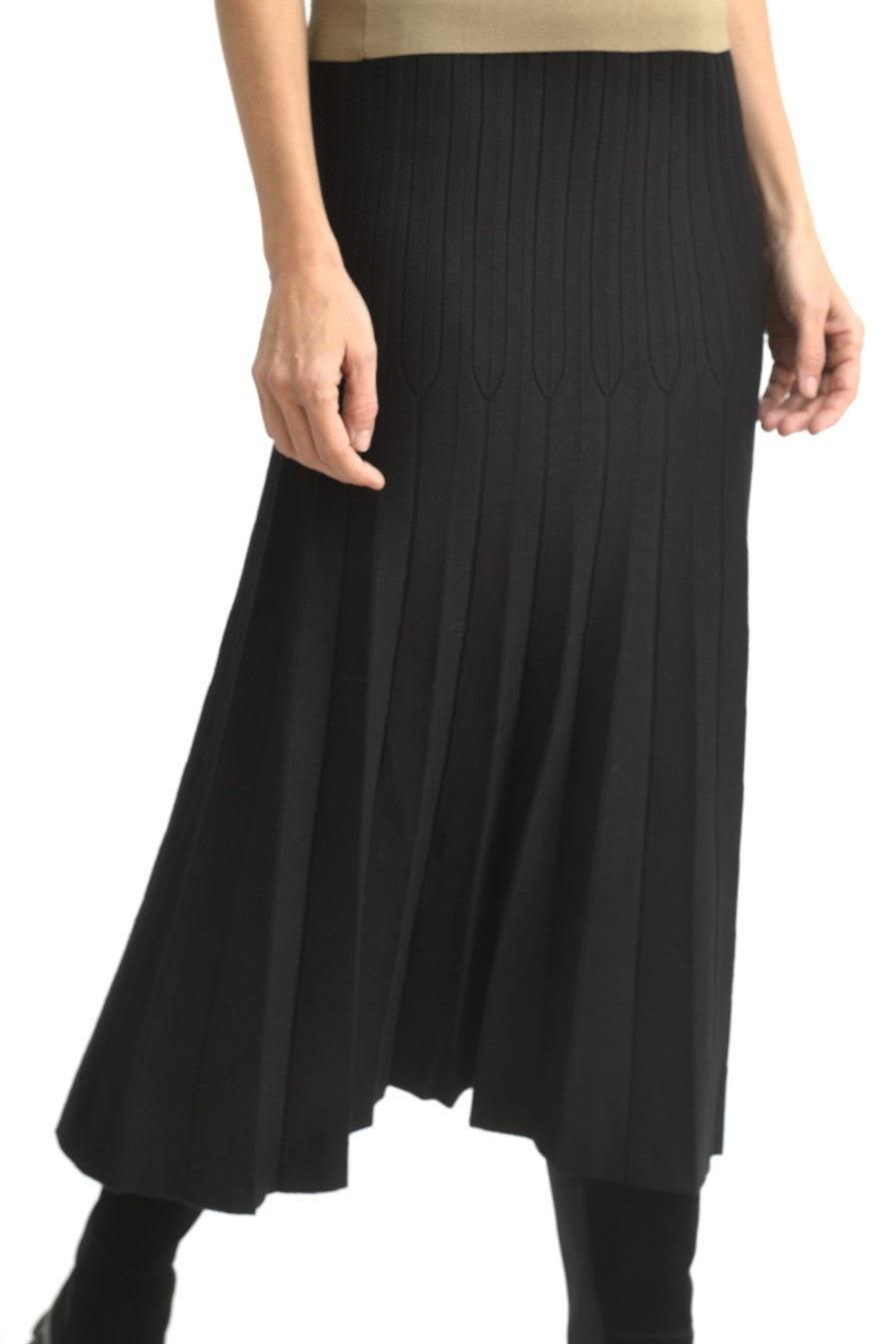 Fustă lungă evazată din tricot ajurat, ilustrată în mișcare pentru a sublinia fluiditatea croielii.