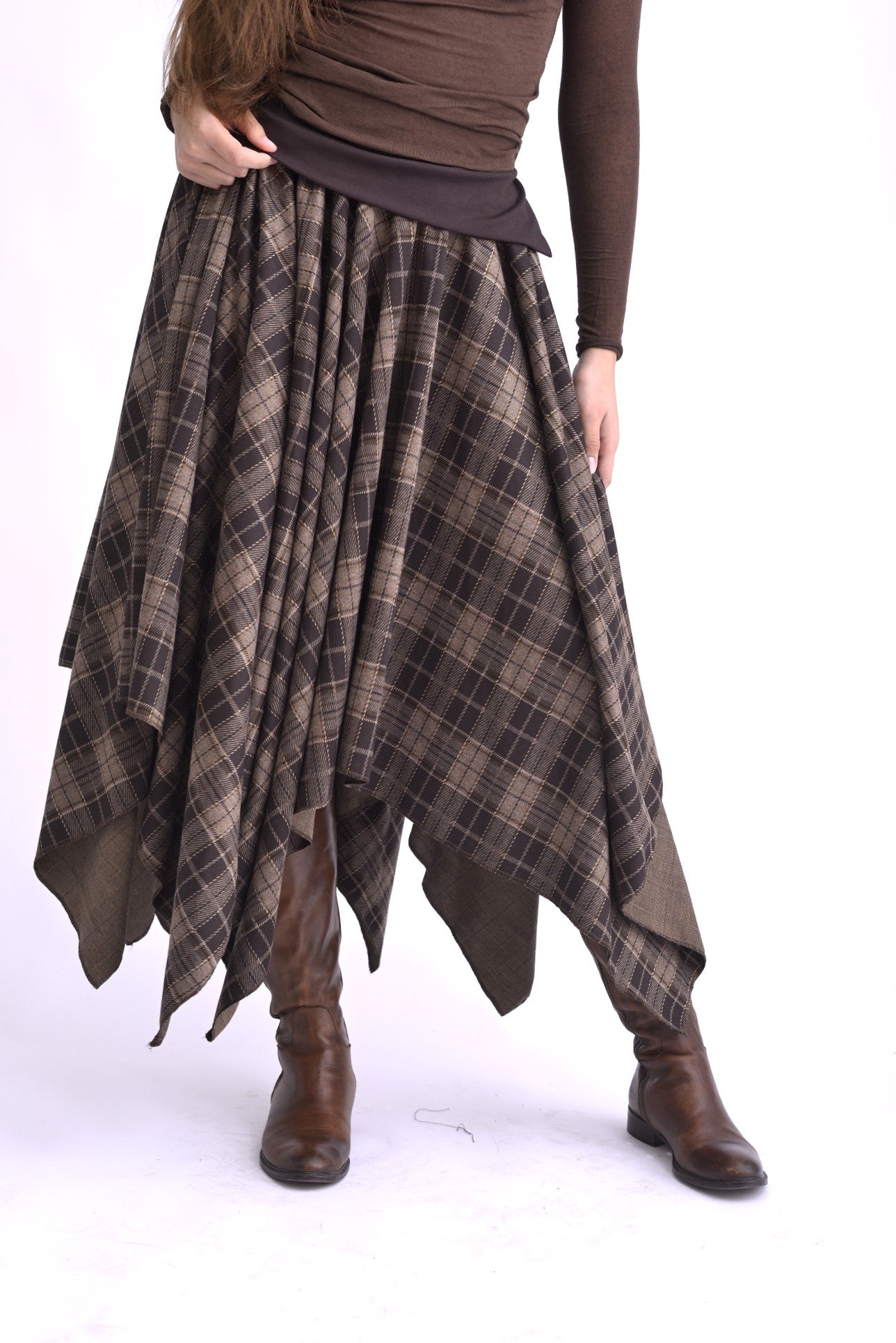 Fustă în colțuri, cu talie elastică și croială asimetrică, realizată din material în carouri, vedere din față pe model.