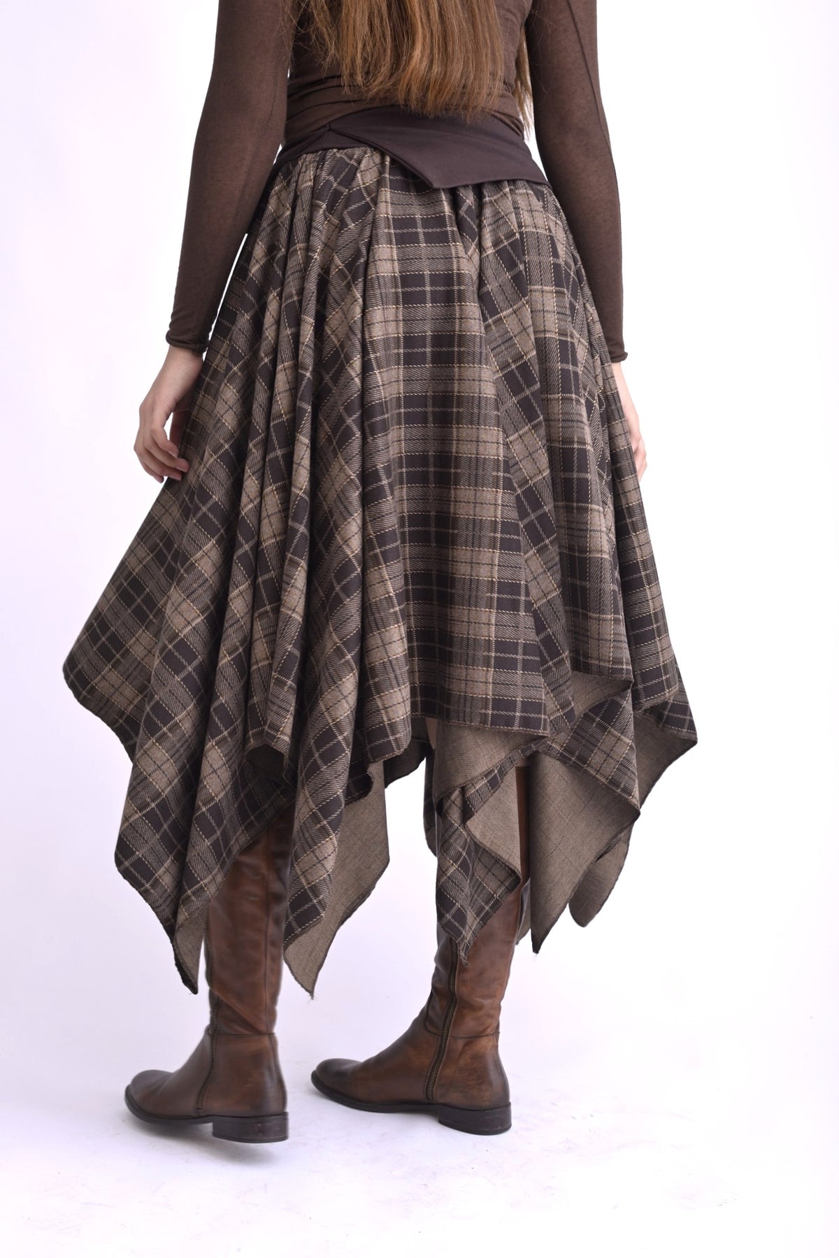 Fustă în colțuri, talie elastică, model cu pliuri lejere, vedere din spate pe model.