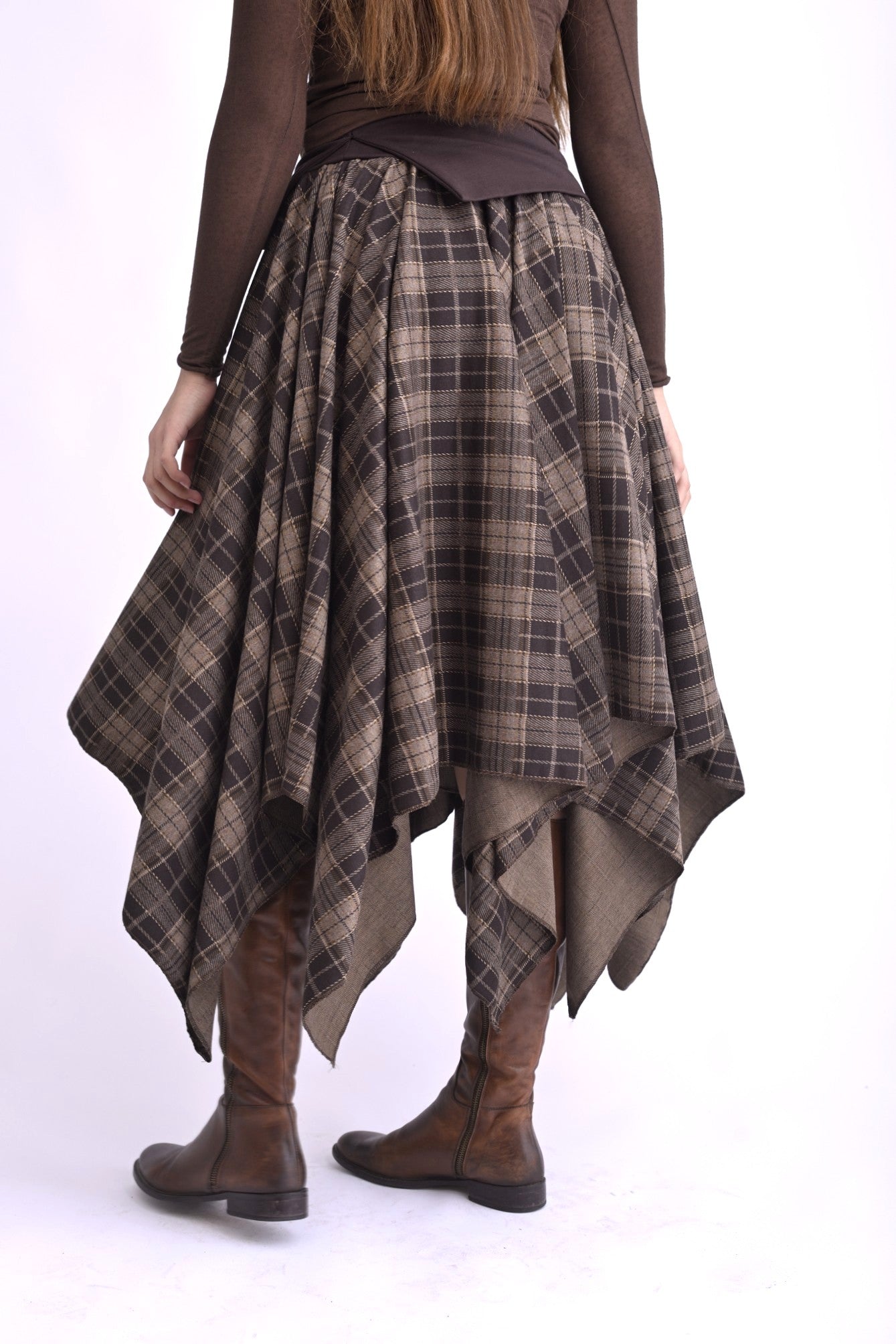 Fustă în colțuri, talie elastică, model cu pliuri lejere, vedere din spate pe model.