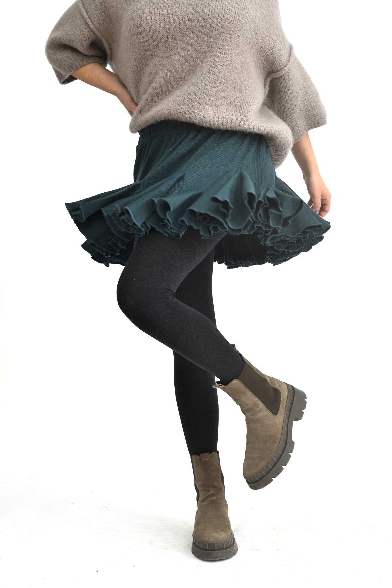 Fustă scurtă din jerse verde, cu talie elastică și multe volane, perfectă pentru un look casual chic.