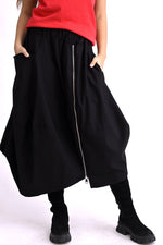Fustă largă neagră cu talie elastică, buzunar lateral și fermoar descentrat, vedere din față.