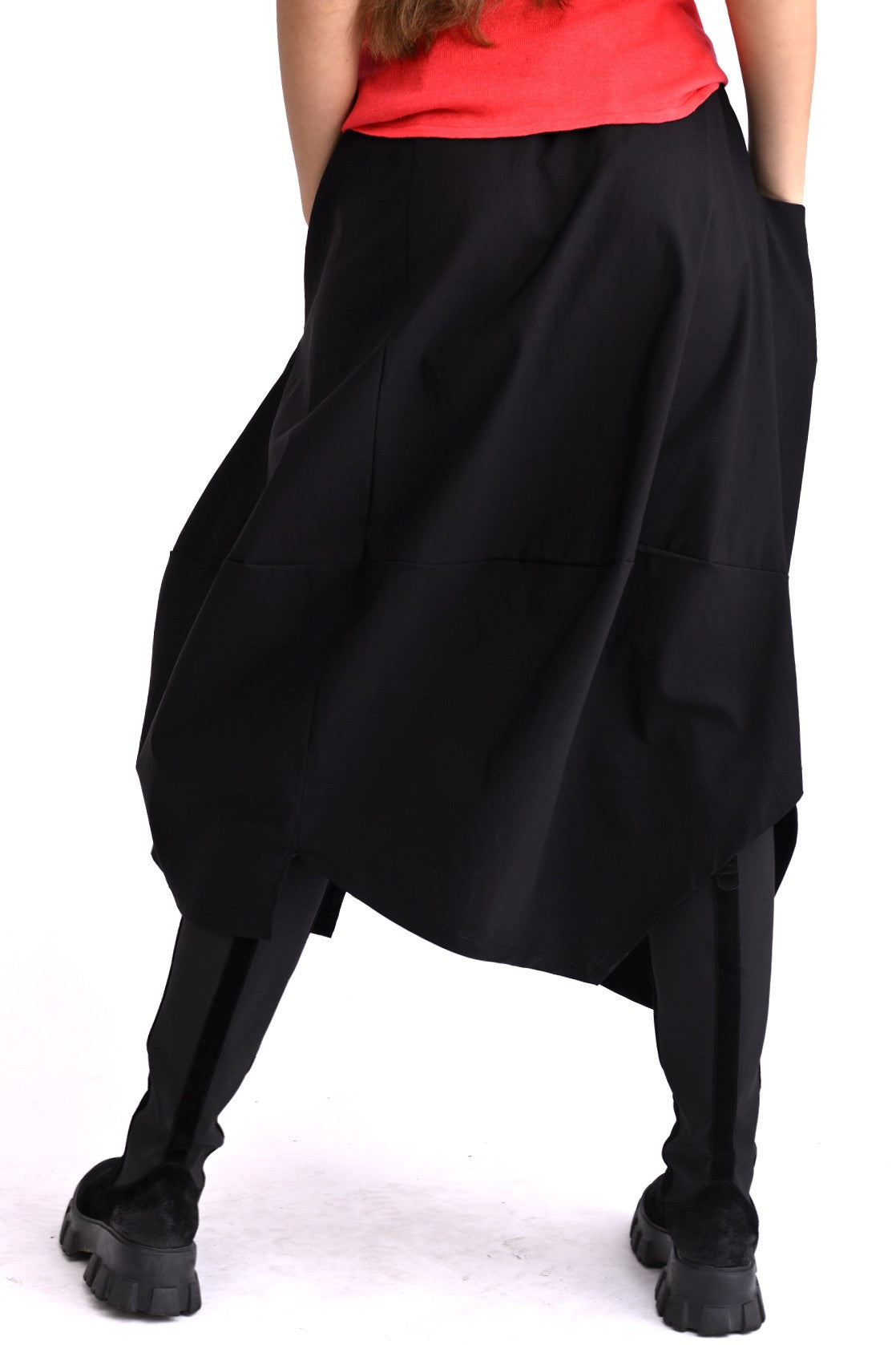 Fustă largă neagră în mișcare, siluetă voluminoasă și buzunar practic.