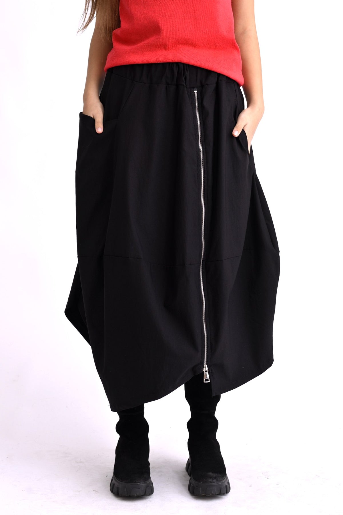 Profilul fustei negre cu croială amplă tip gogoșar, buzunar lateral și talie elastică.