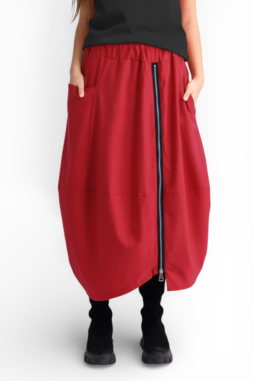 Profilul fustei rosie cu croială amplă tip gogoșar, buzunar lateral și talie elastică.