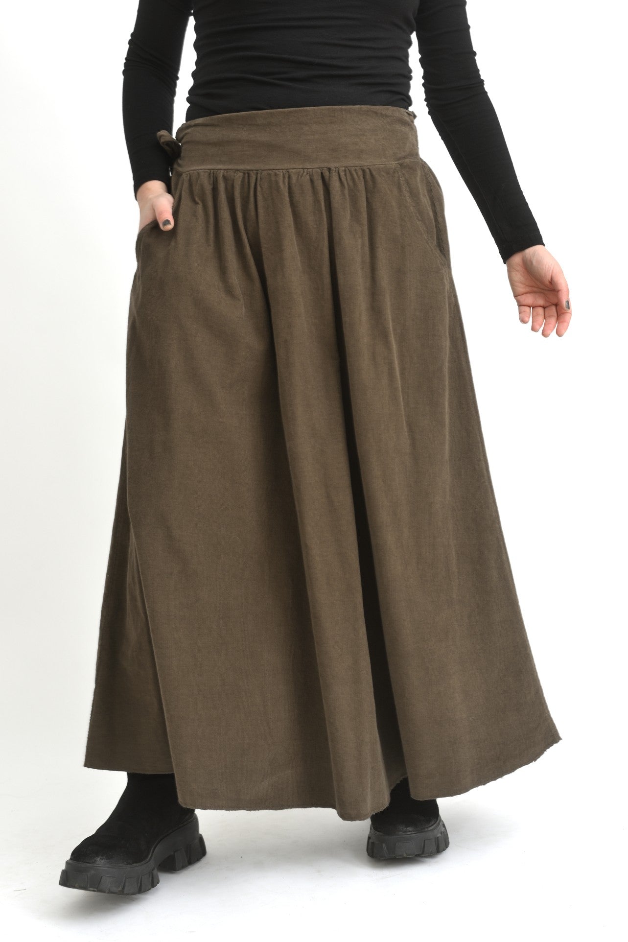 Fustă lungă bej din catifea reiată, fotografiată lateral, evidențiind textura din catifea și volumul croielii.