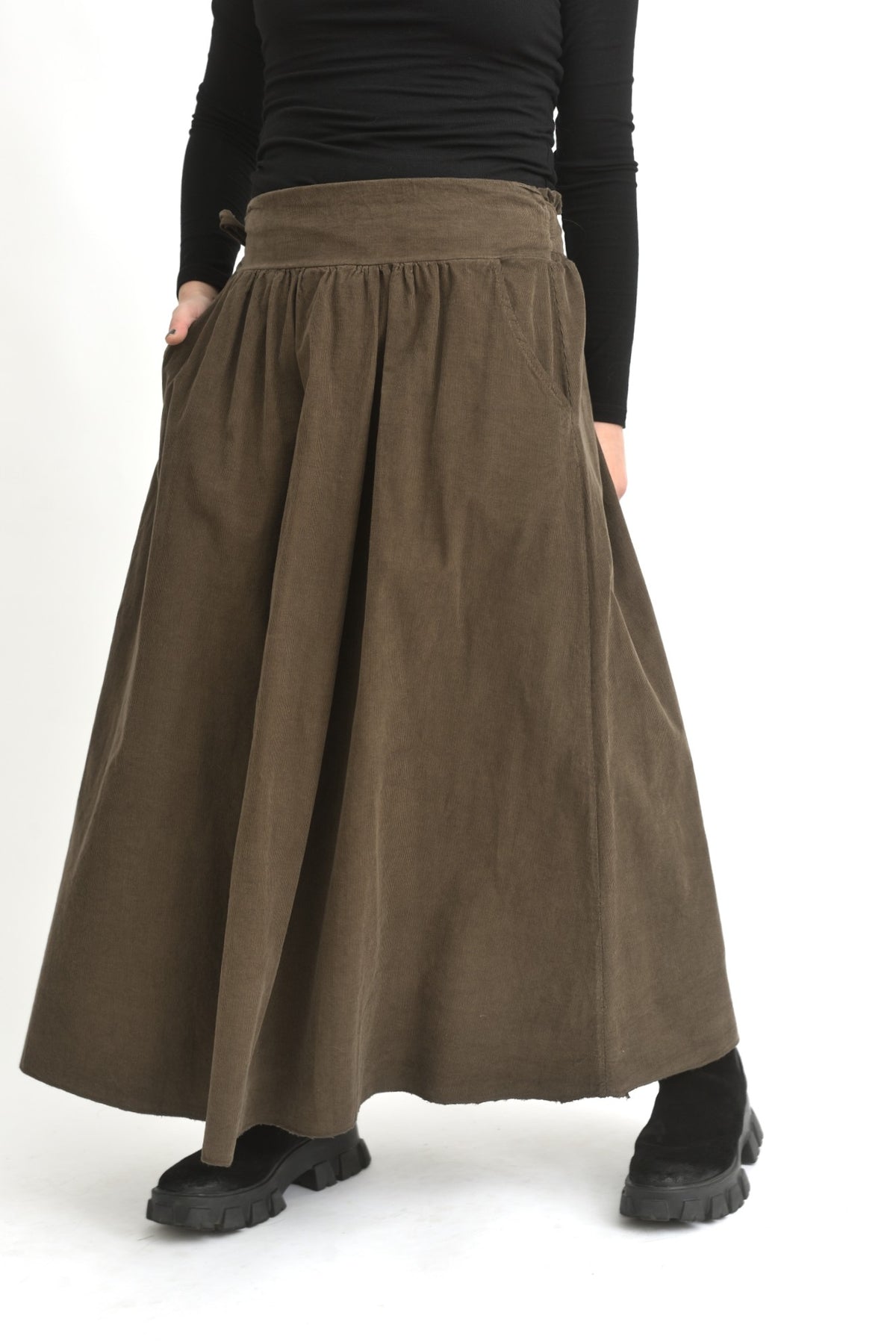 Fustă lungă din catifea reiată maro, cu talie elastică și cădere amplă, afișată pe model.