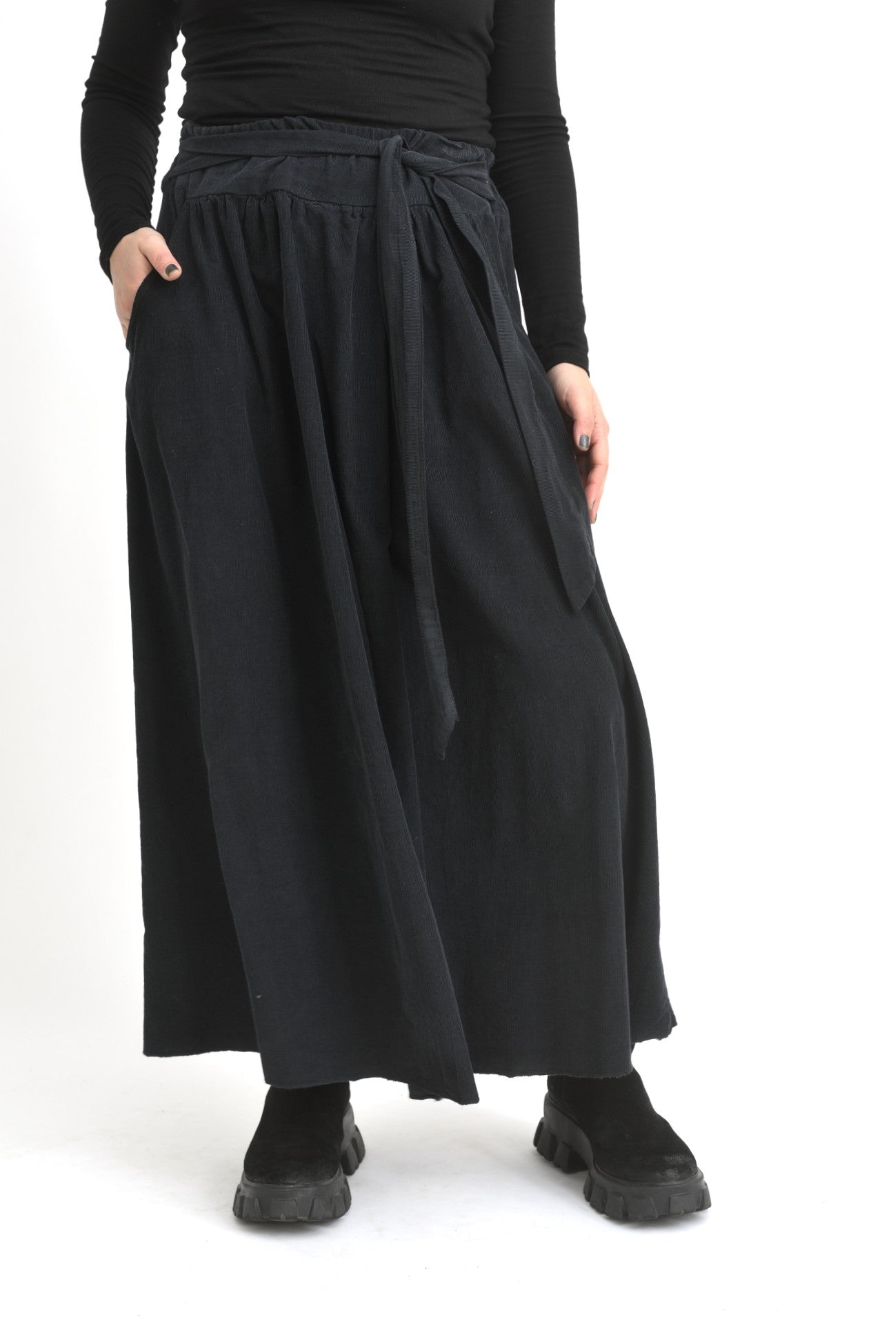Fustă lungă neagră din catifea reiată, cu croială amplă și talie elastică, purtată pe model.