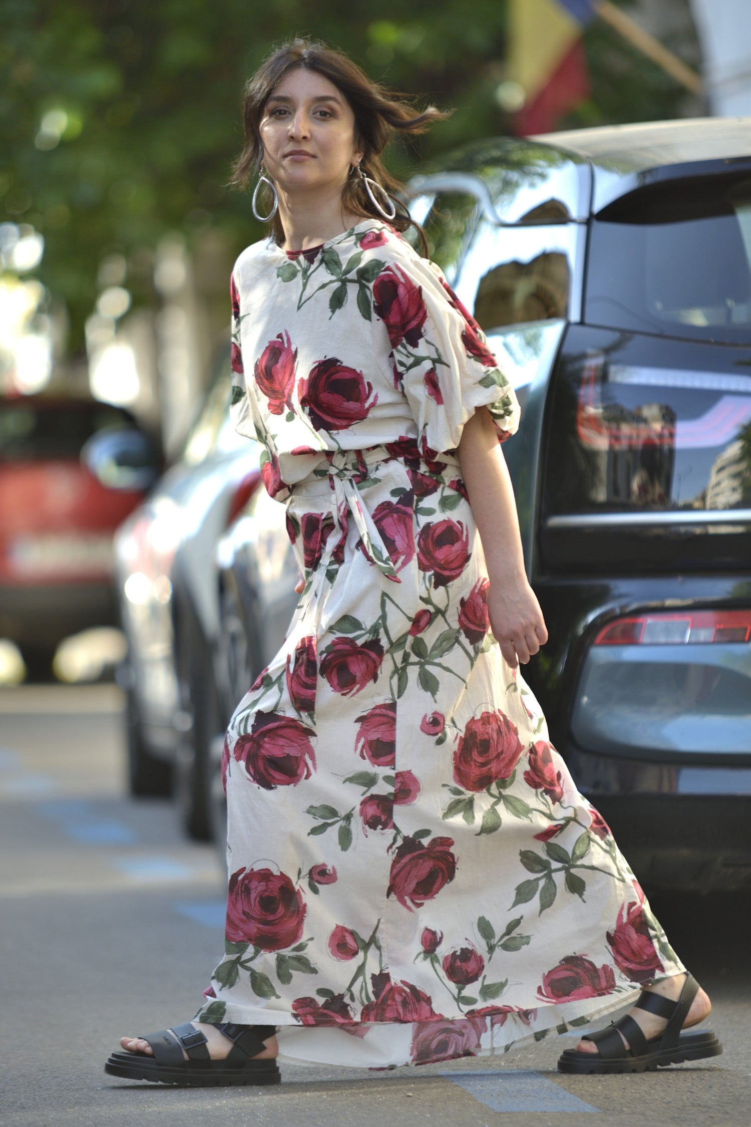  Fustă albă lungă cu imprimeu floral și talie marcată, purtată cu bluză asortată, fotografiată din lateral.